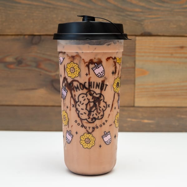 Mochinut chocolate boba drink with chocolate syrup swirls in a branded cup.